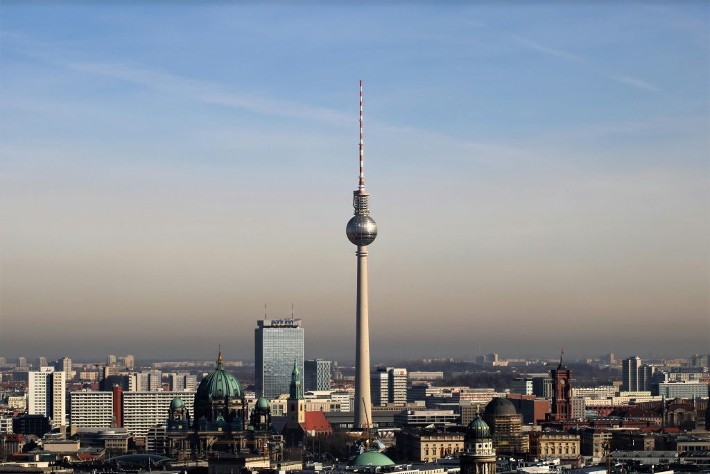Admire Berlin's urban skyline featuring the iconic Fernsehturm tower against a clear blue sky.