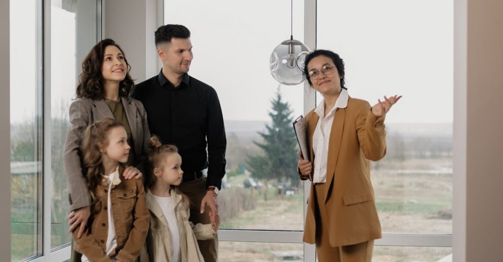 Family touring a new home guided by a real estate agent in a bright room.